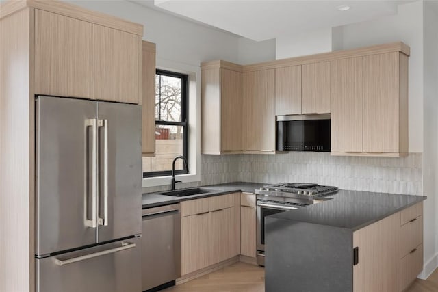 kitchen featuring appliances with stainless steel finishes, light hardwood / wood-style flooring, tasteful backsplash, light brown cabinetry, and sink