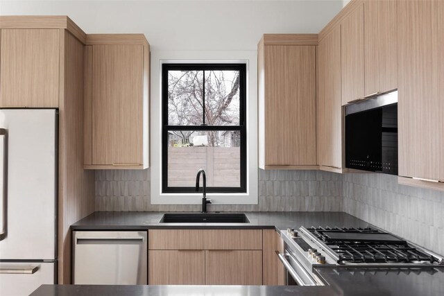 kitchen with backsplash, stainless steel appliances, sink, and light brown cabinets