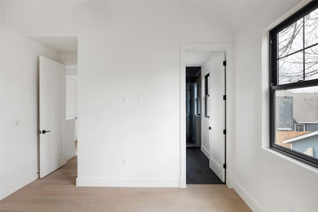 unfurnished bedroom with light hardwood / wood-style flooring and vaulted ceiling