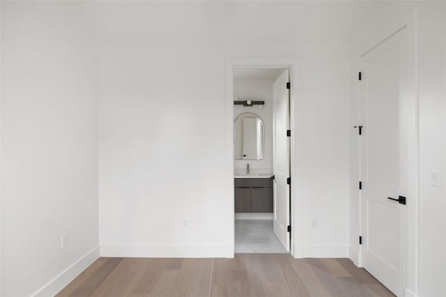 corridor featuring light hardwood / wood-style flooring and sink