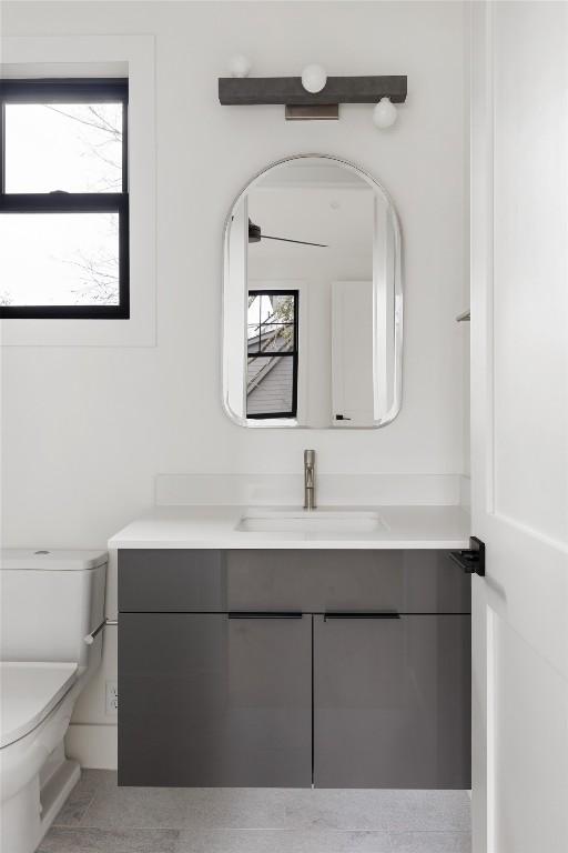 bathroom featuring a healthy amount of sunlight, vanity, and toilet