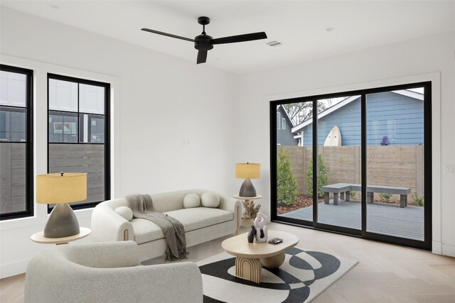 living room with ceiling fan and light parquet flooring