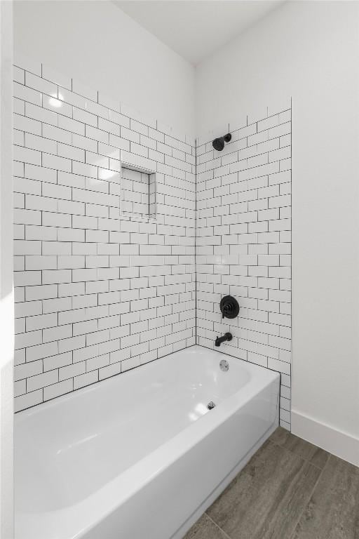 bathroom with tiled shower / bath combo and hardwood / wood-style floors