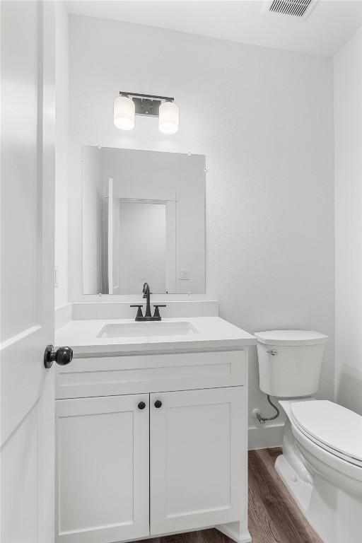 bathroom with vanity, wood-type flooring, and toilet