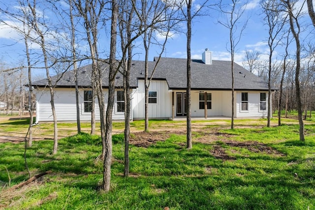 rear view of house featuring a yard