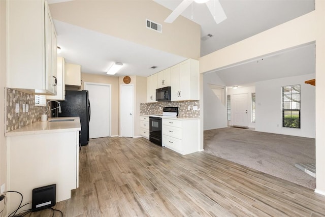 kitchen featuring sink, white cabinetry, black appliances, light wood-type flooring, and backsplash