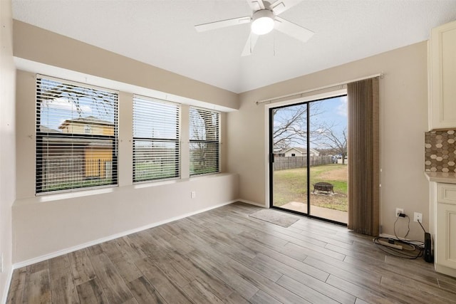 empty room featuring vaulted ceiling, ceiling fan, and light hardwood / wood-style floors