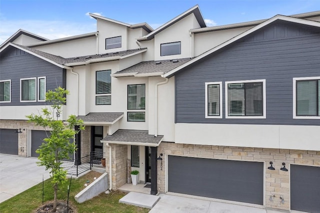 multi unit property featuring a garage, stone siding, a shingled roof, and stucco siding