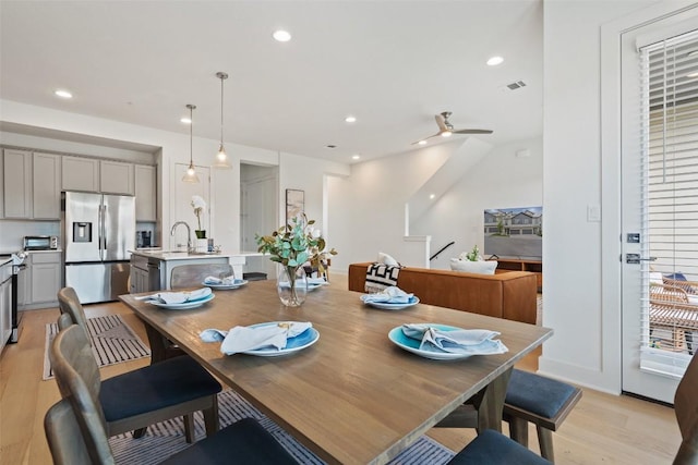 dining area featuring ceiling fan, sink, and light hardwood / wood-style floors