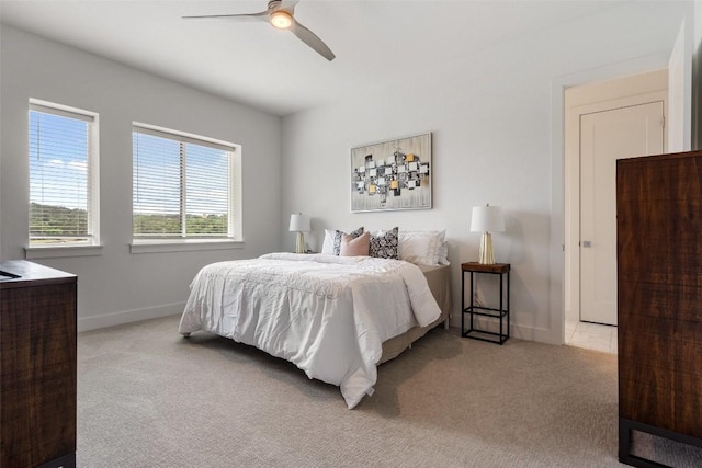 bedroom with baseboards, ceiling fan, and light colored carpet