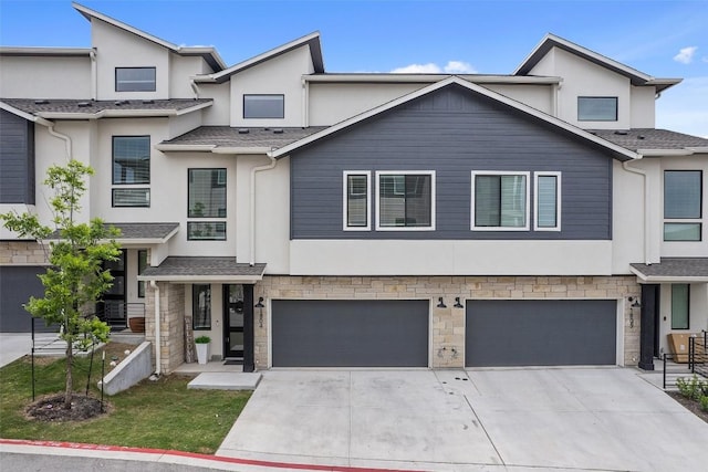 view of front of home featuring driveway, stone siding, and stucco siding