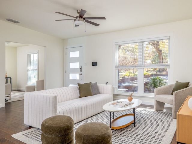 living room with dark wood-type flooring and ceiling fan