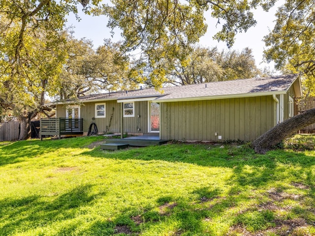 back of property with a yard and a deck