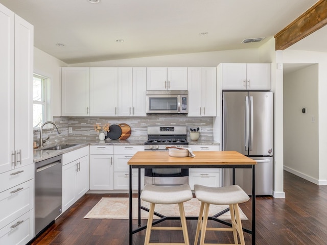 kitchen featuring backsplash, appliances with stainless steel finishes, sink, and white cabinets