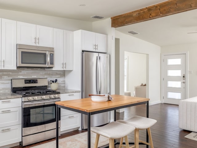 kitchen featuring white cabinetry, appliances with stainless steel finishes, light stone counters, and decorative backsplash