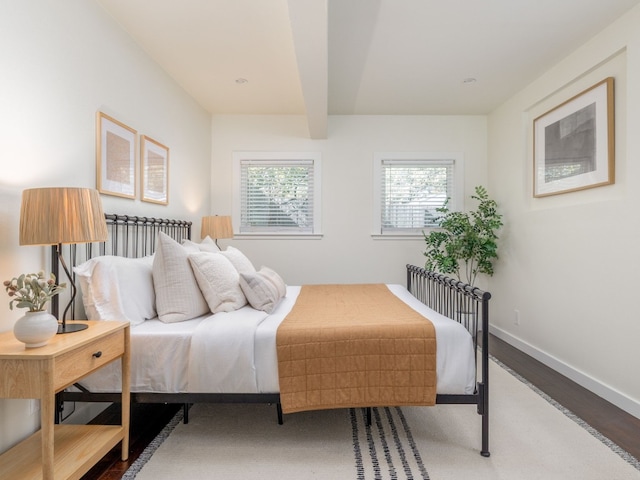 bedroom with hardwood / wood-style flooring and beam ceiling