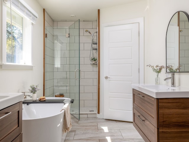 bathroom with vanity and shower with separate bathtub