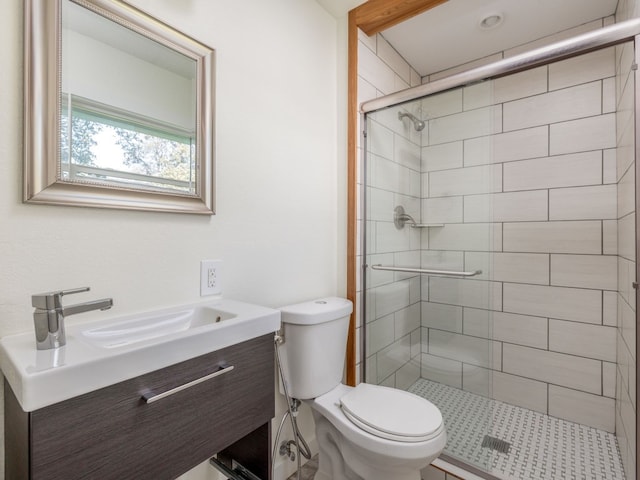 bathroom with vanity, a shower with shower door, and toilet