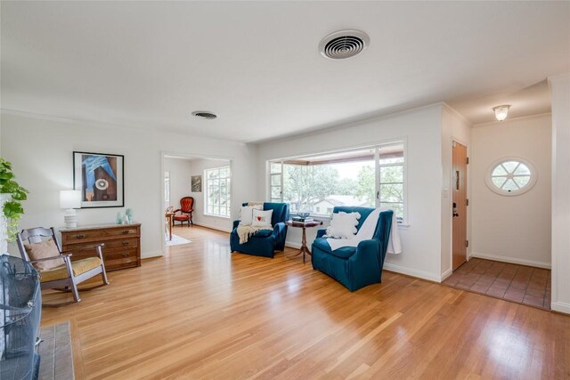 living area featuring hardwood / wood-style flooring and crown molding