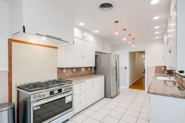 kitchen with sink, decorative light fixtures, white cabinets, stainless steel appliances, and backsplash