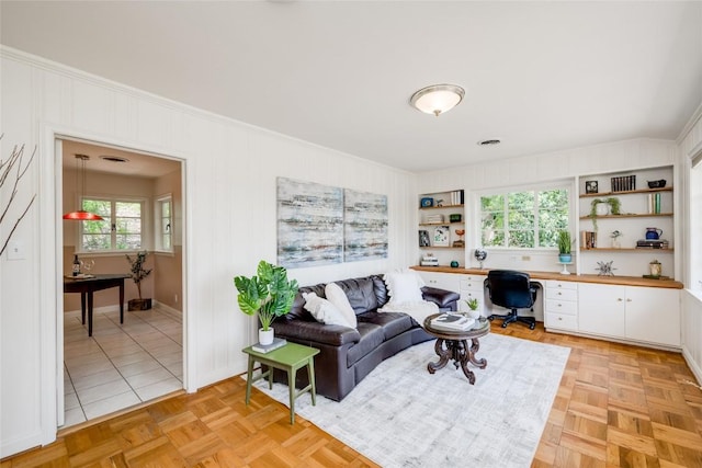 living room with crown molding and light parquet floors