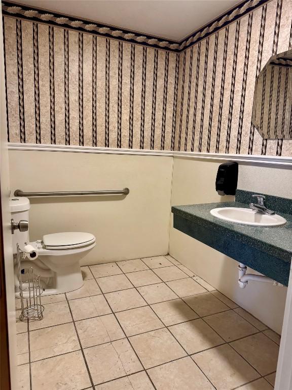 bathroom featuring toilet, tile patterned flooring, and sink