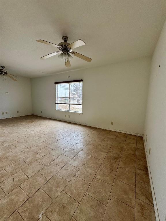 empty room with a textured ceiling and ceiling fan