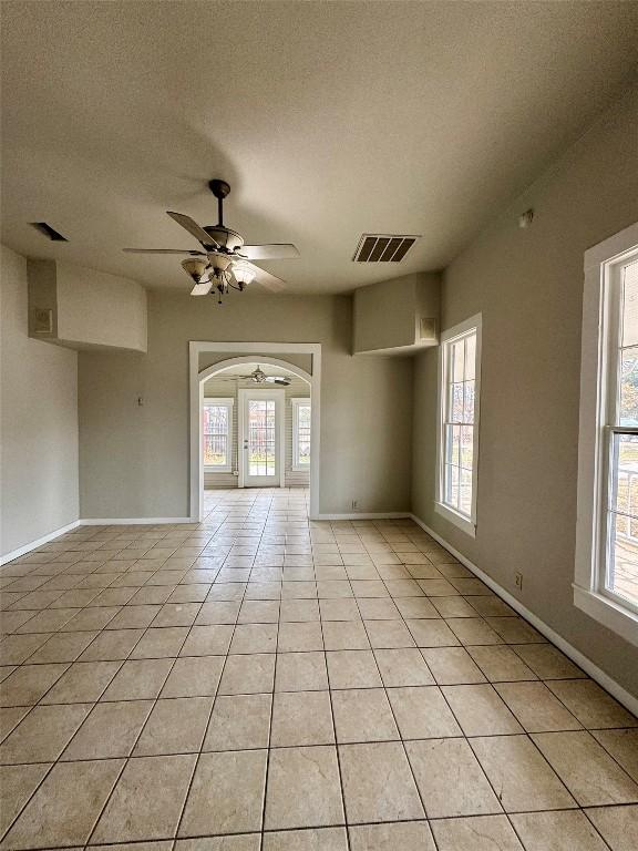 tiled spare room with a textured ceiling and ceiling fan