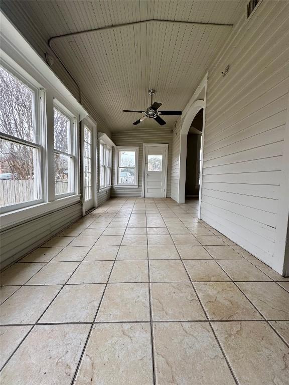 unfurnished sunroom with wood ceiling and ceiling fan