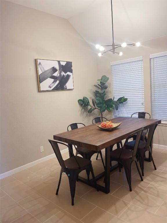 dining space featuring lofted ceiling and a chandelier