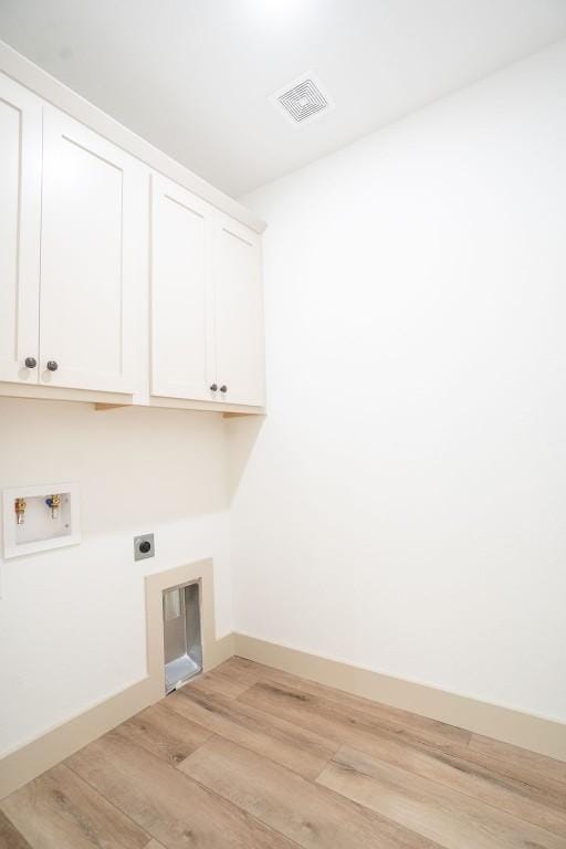 laundry room with cabinets, hookup for a washing machine, light wood-type flooring, and electric dryer hookup