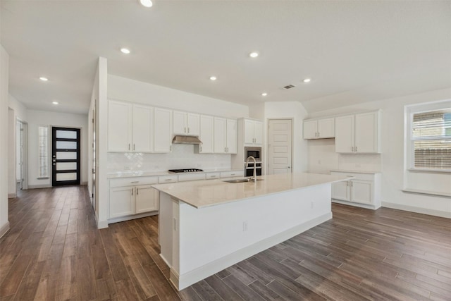 kitchen with white cabinetry, sink, a kitchen island with sink, and black gas cooktop