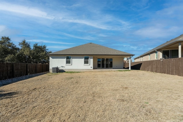 rear view of property with cooling unit, a lawn, and a patio