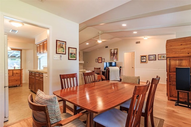 dining area with vaulted ceiling, ceiling fan, and light wood-type flooring