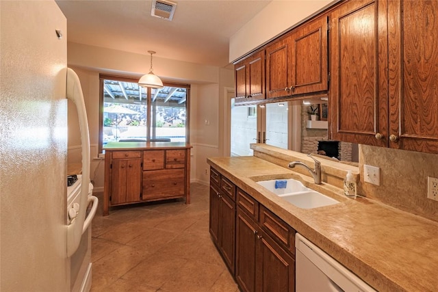 kitchen with hanging light fixtures, sink, and white appliances