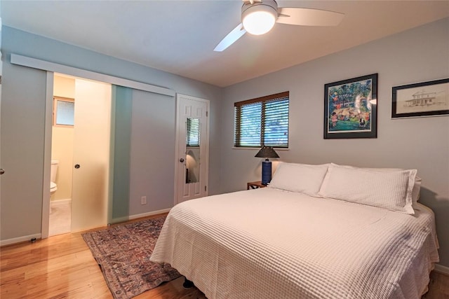 bedroom with connected bathroom, light hardwood / wood-style flooring, and ceiling fan