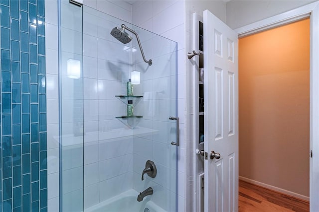 bathroom with hardwood / wood-style floors and tiled shower / bath combo