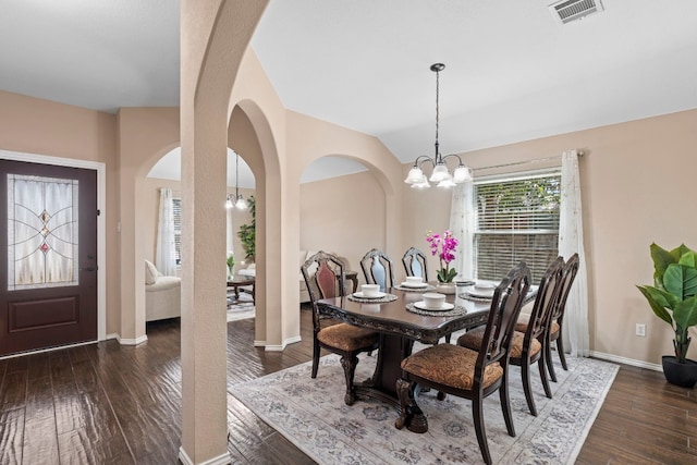 dining room with an inviting chandelier, dark hardwood / wood-style floors, and vaulted ceiling