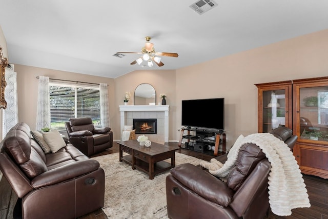 living room with hardwood / wood-style flooring, ceiling fan, lofted ceiling, and a fireplace