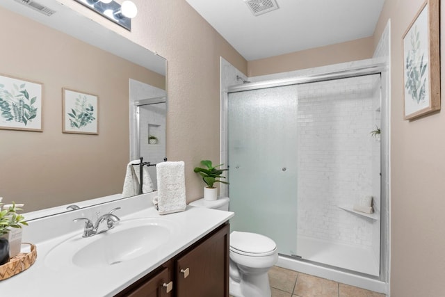 bathroom featuring vanity, tile patterned flooring, a shower with shower door, and toilet