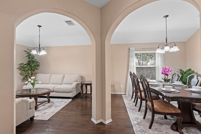 dining area featuring a notable chandelier and dark wood-type flooring