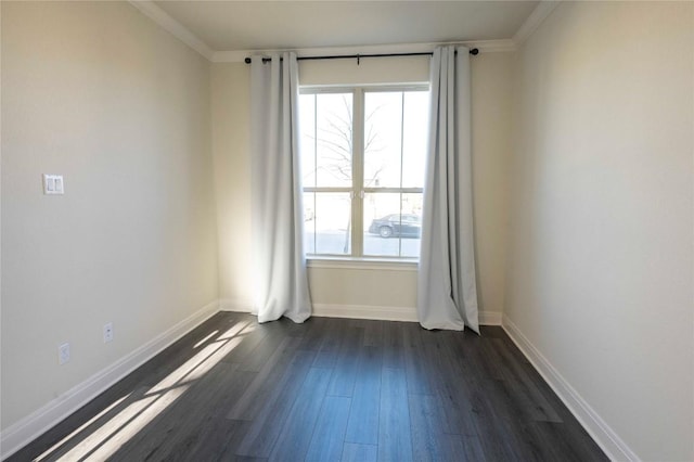 spare room featuring ornamental molding and dark hardwood / wood-style floors