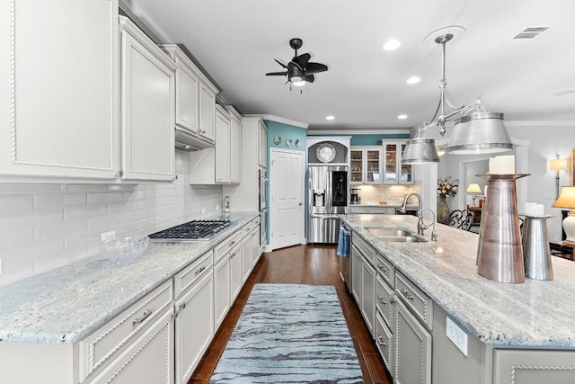 kitchen featuring sink, light stone counters, appliances with stainless steel finishes, an island with sink, and white cabinets