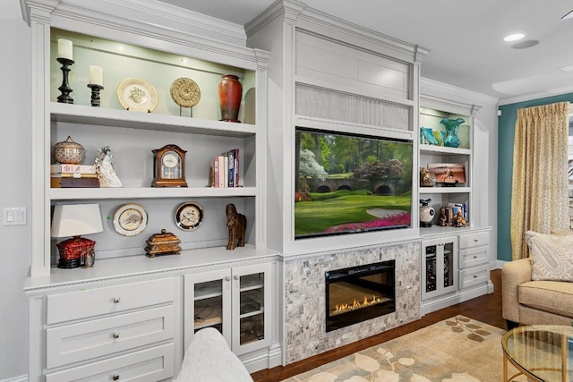 living area with hardwood / wood-style flooring, ornamental molding, and built in features