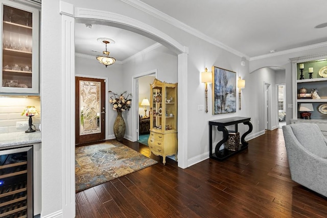 entryway featuring ornamental molding, bar, wine cooler, and dark hardwood / wood-style flooring