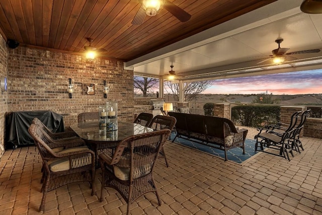 dining room featuring brick wall, wooden ceiling, and ceiling fan