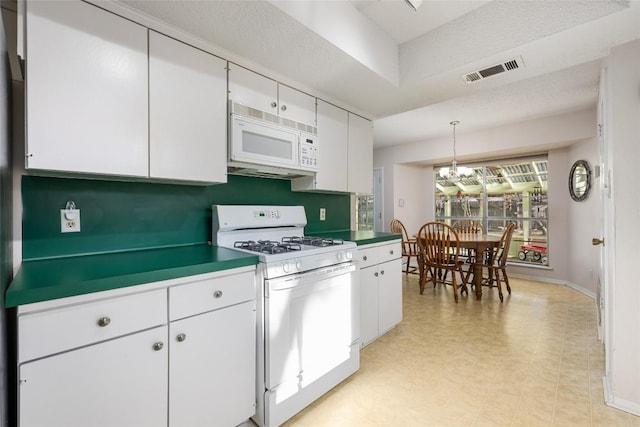 kitchen featuring hanging light fixtures, white cabinetry, an inviting chandelier, and white appliances