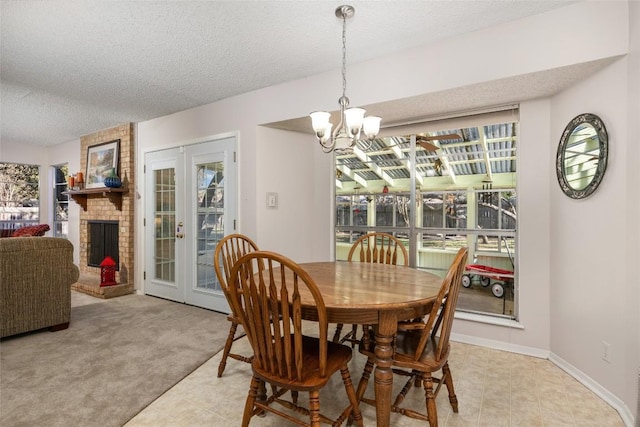 carpeted dining room with french doors, a fireplace, a chandelier, and a textured ceiling