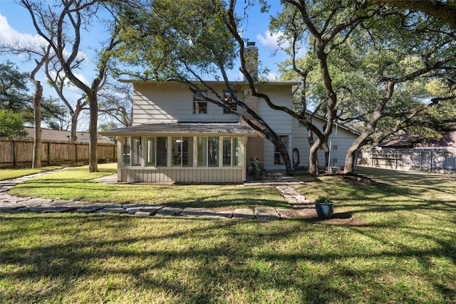 rear view of property featuring a lawn