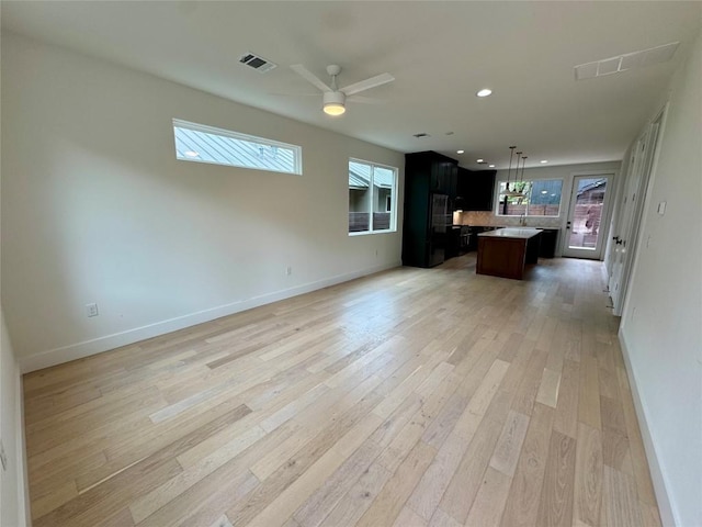 1708 Canterbury St Unit 1, Austin, TX 78702 - unfurnished living room with light wood-style floors, baseboards, a ceiling fan, and recessed lighting